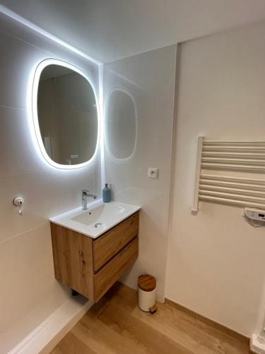 La salle de bains est pourvue d'un lavabo et d'un miroir. dans l'établissement Vivez l'Horizon sur la mer - Vue mer - plage - Port de plaisance, au Havre