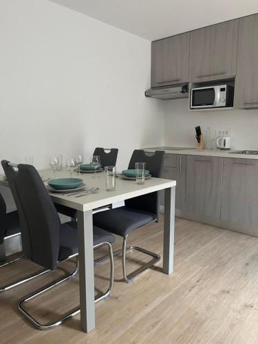 un tavolo da pranzo con sedie e una cucina di Apartma Melinc a Bovec