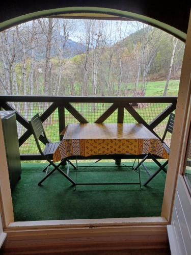 einen Tisch und einen Stuhl auf einer abgeschirmten Veranda in der Unterkunft le chamois d or in Allos