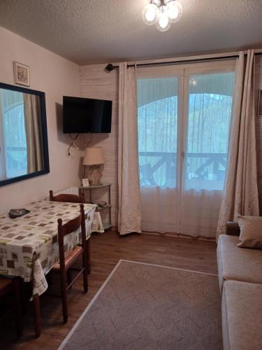 a living room with a table and a large window at le chamois d or in Allos