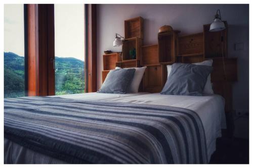 a bedroom with two beds with a large window at Gêres! Caniçada House! in Geres