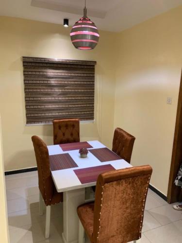 a dining room with a table and chairs and a window at Rehoboth Homes in Port Harcourt