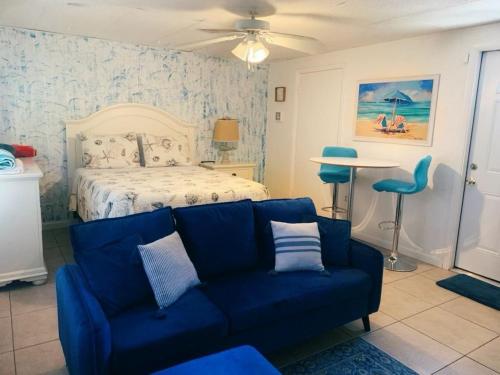 een woonkamer met een blauwe bank en een bed bij Cozy Studio only 10 minutes by car of Siesta Key in Sarasota