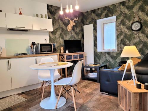 a kitchen and living room with a table and chairs at Le Petit Clos, 3 étoiles in Pont-Saint-Martin