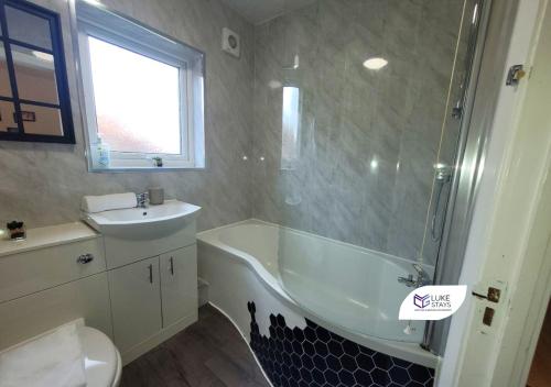 a bathroom with a bath tub and a sink at Luke Stays - Chilside Road in Felling