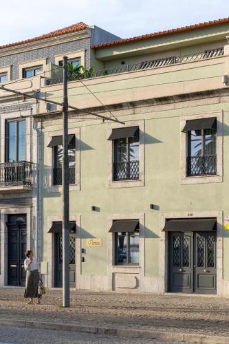 a woman walking in front of a building at Portie Deluxe Suites by DA'HOME in Porto