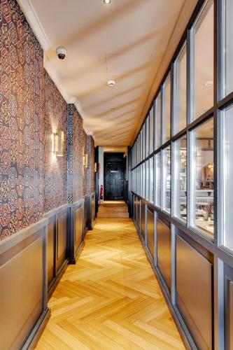 a corridor of a restaurant with windows and wooden floors at Portie Deluxe Suites by DA'HOME in Porto