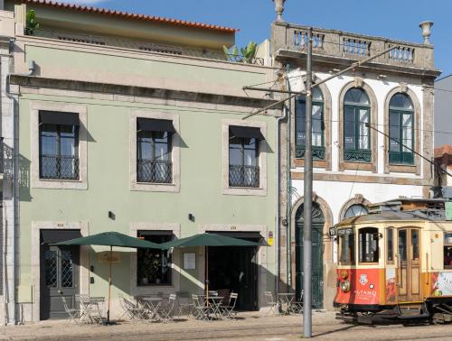 an old trolley car parked in front of a building at Portie Deluxe Suites by DA'HOME in Porto