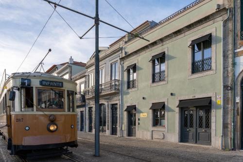 an old trolley car on a street in front of a building at Portie Deluxe Suites by DA'HOME in Porto