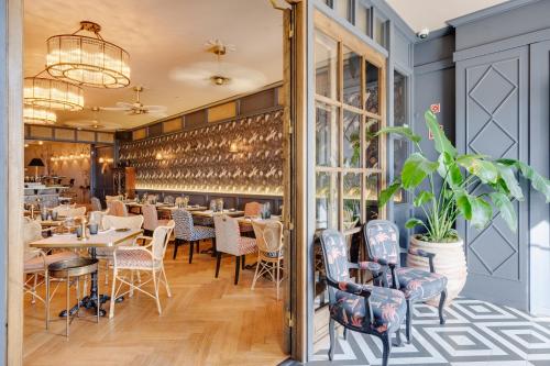 un restaurant avec des tables et des chaises et un mur de fenêtres dans l'établissement Portie Deluxe Suites by DA'HOME, à Porto