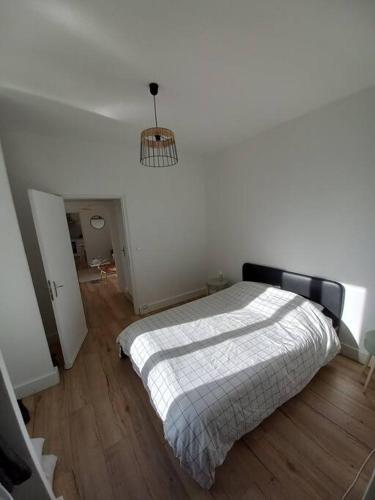 une chambre avec un lit dans une pièce blanche dans l'établissement Le scandinave de Vendargues, à Vendargues