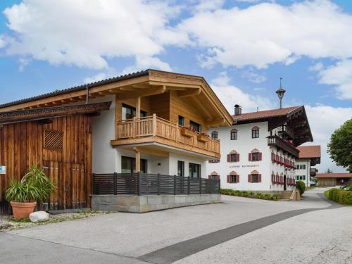 ein Haus mit einem Balkon an der Seite in der Unterkunft Hotel Baumgarten & Chalet Baumgarten in Angerberg