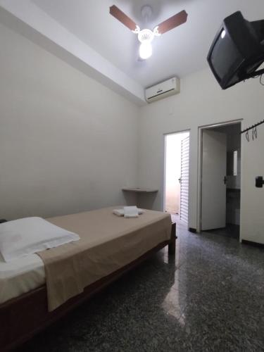 een slaapkamer met een bed en een plafondventilator bij BIGS HOTEL in Penápolis