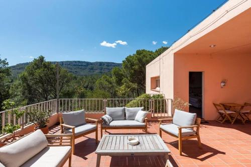 um pátio com sofás, uma mesa e cadeiras em AldeaMia, Forest, mountain view, beach at 8 min em Vilanova de Escornalbou