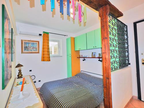 1 dormitorio con 1 cama en una habitación con armarios coloridos en Belvedere Di Lerici, en Lerici