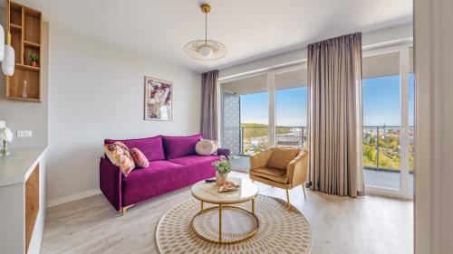 sala de estar con sofá púrpura y mesa en Apartamenty Sun & Snow Modern Tower en Gdynia