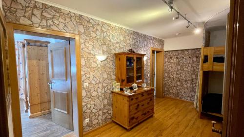 a room with a stone wall with a dresser and a mirror at Ferienwohnung Brandmaier in Unken