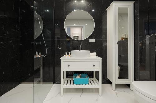 a bathroom with a sink and a mirror at Plażowa Park Apartment with Garden by Renters in Międzywodzie