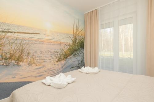 a bedroom with a bed with a view of the beach at Plażowa Park Apartment with Garden by Renters in Międzywodzie