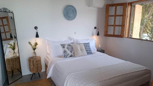 アルハンゲロスにあるKtima Naturaのベッドルーム1室(白いベッド1台、枕付)、窓が備わります。