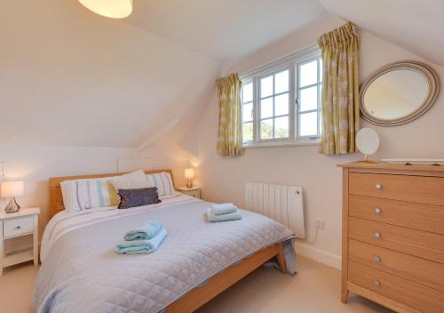 a bedroom with a bed with two towels on it at 4 Dormy House in Brancaster