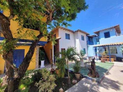 una casa con un árbol delante de ella en Pousada Maresias de Geribá en Búzios