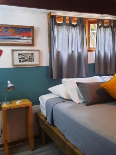 a bedroom with two beds and a table with a lamp at Casa SILURI in Santa Teresa Beach