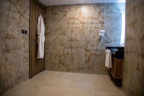 bagno con doccia e parete in pietra di Jeddah Homes Boutique Hotel ad Amman