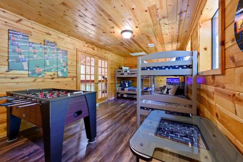 a room with a game table and a bunk bed at Hickory Bear - Cabin surrounded by pines, Sleeps 10, Hot Tub, Fire Pit, Arcade, Foosball Table & Deck Slide in Broken Bow
