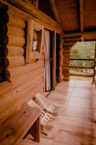 an inside view of a log cabin with a bench at Refúgio do Caracol Pipas e Chalés in Canela
