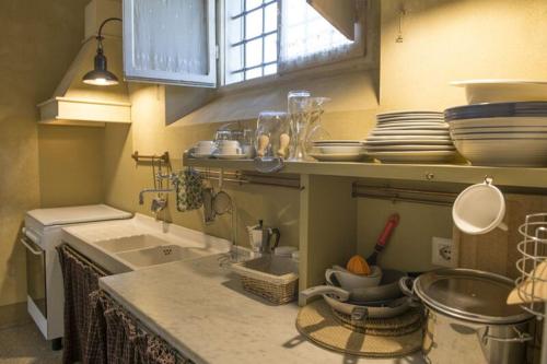 eine Küche mit einer Spüle und einer Theke mit Geschirr in der Unterkunft Bello Stare by PosarelliVillas in Cantagrillo