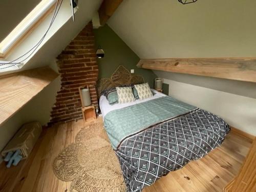a bedroom with a large bed in a attic at La maison du bonheur "Le petit Four" in Saint-Ouen-sous-Bailly