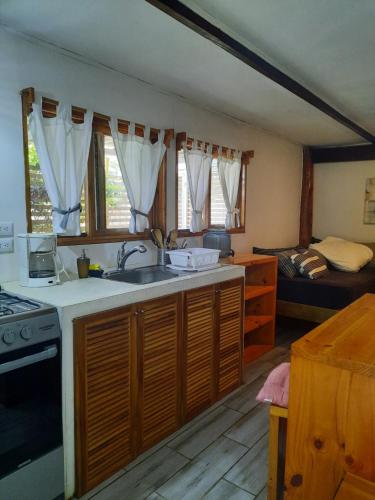 una cocina con fregadero y una cama en una habitación en Casa SILURI, en Santa Teresa Beach