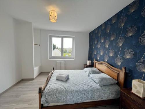 una camera con un letto con una parete blu di Le gite du Presbytère du Talbert a Pleubian