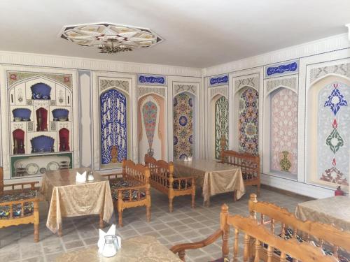 comedor con mesas, sillas y vidrieras en Hotel Fatima Boutique, en Bukhara