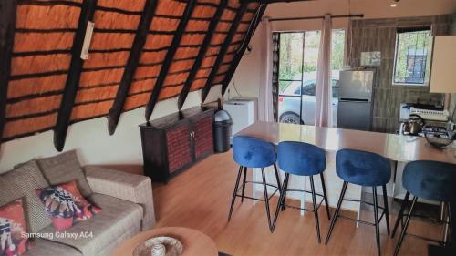 a kitchen and living room with a counter and chairs at Entire Eco Home, Magaliesburg in Buffelspoort