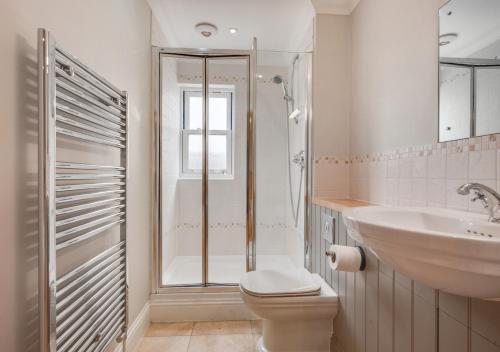 ein Bad mit einer Dusche, einem WC und einem Waschbecken in der Unterkunft Admirals Lodge in Thornham