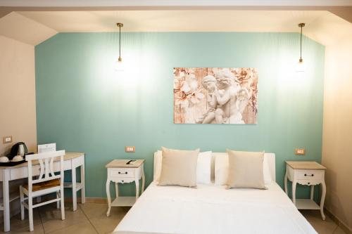 a bedroom with a bed and a desk and a painting on the wall at Riverbed in Sarno