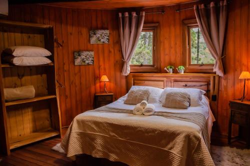 a bedroom with a bed with two towels on it at Refúgio do Caracol Pipas e Chalés in Canela