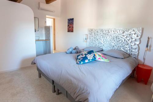 a bedroom with a large bed with blue pillows at Mas Picholine - Maison pour 10 avec piscine in Saint-Jean-de-Maruéjols-et-Avéjan