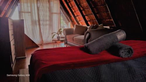 a bedroom with a bed and a couch in a room at Entire Eco Home, Magaliesburg in Buffelspoort