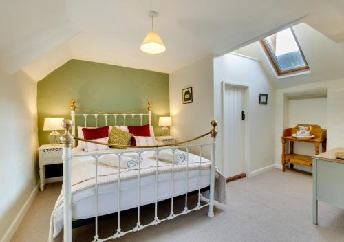 a bedroom with a bed and a skylight at Angel Cottage in Burnham Market