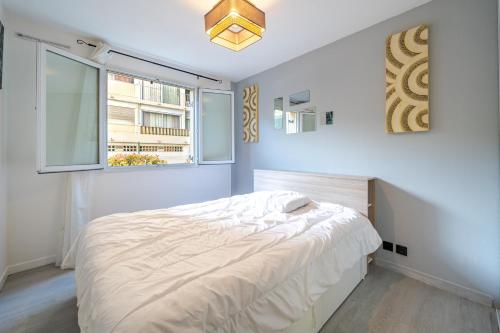 une chambre blanche avec un lit et une fenêtre dans l'établissement Charmant appartement proche gare, à Nice