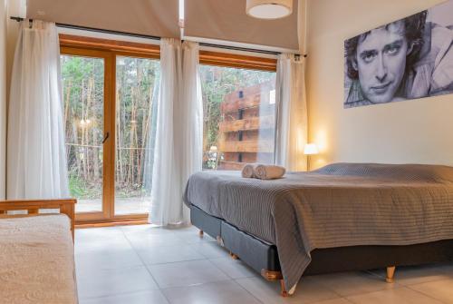 a bedroom with a large bed and a large window at Los Amancays 2 in Villa La Angostura