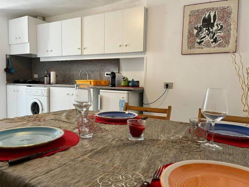 una cocina con una mesa con platos y copas de vino en Appartamento Domarì, en Turi