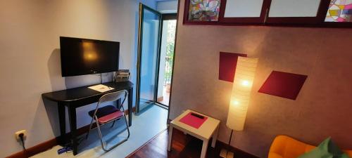 sala de estar con TV y escritorio con silla en Donostia Green+Parking, en San Sebastián