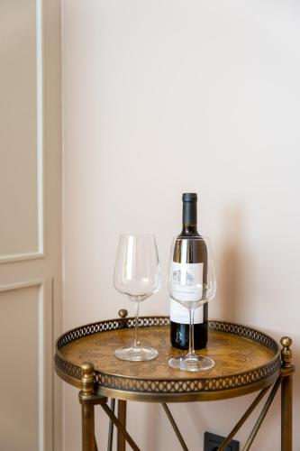 a bottle of wine and two glasses on a table at Portie Deluxe Suites by DA'HOME in Porto