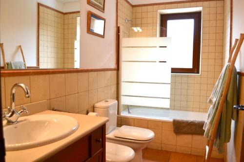 a bathroom with a sink and a toilet and a tub at Apartament rústic amb llar de foc by RURAL D'ÀNEU in Valencia de Aneu