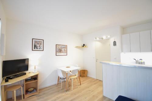 une cuisine avec un comptoir et une table avec des chaises dans l'établissement Balcons du port - Capbreton - A proximite immédiate du port de plaisance, studio en rez de chaussée avec cour dans résidence, à Capbreton