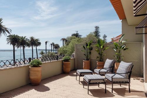uma varanda com cadeiras e vista para o oceano em Portie Deluxe Suites by DA'HOME no Porto